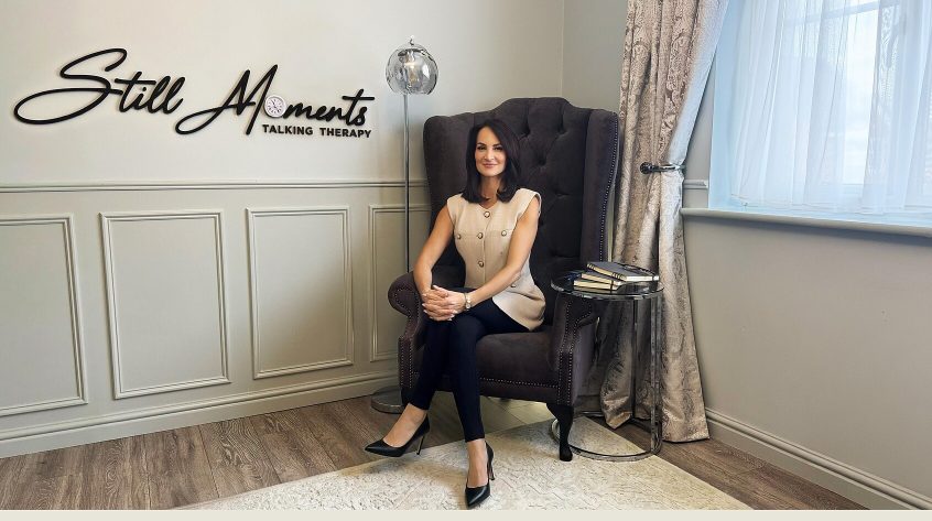 Still Moments Talking Therapy website homepage showing therapist seated in a calm consultation setting.